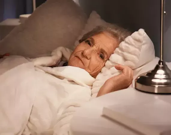 Ältere Frau liegt nachts wach.
